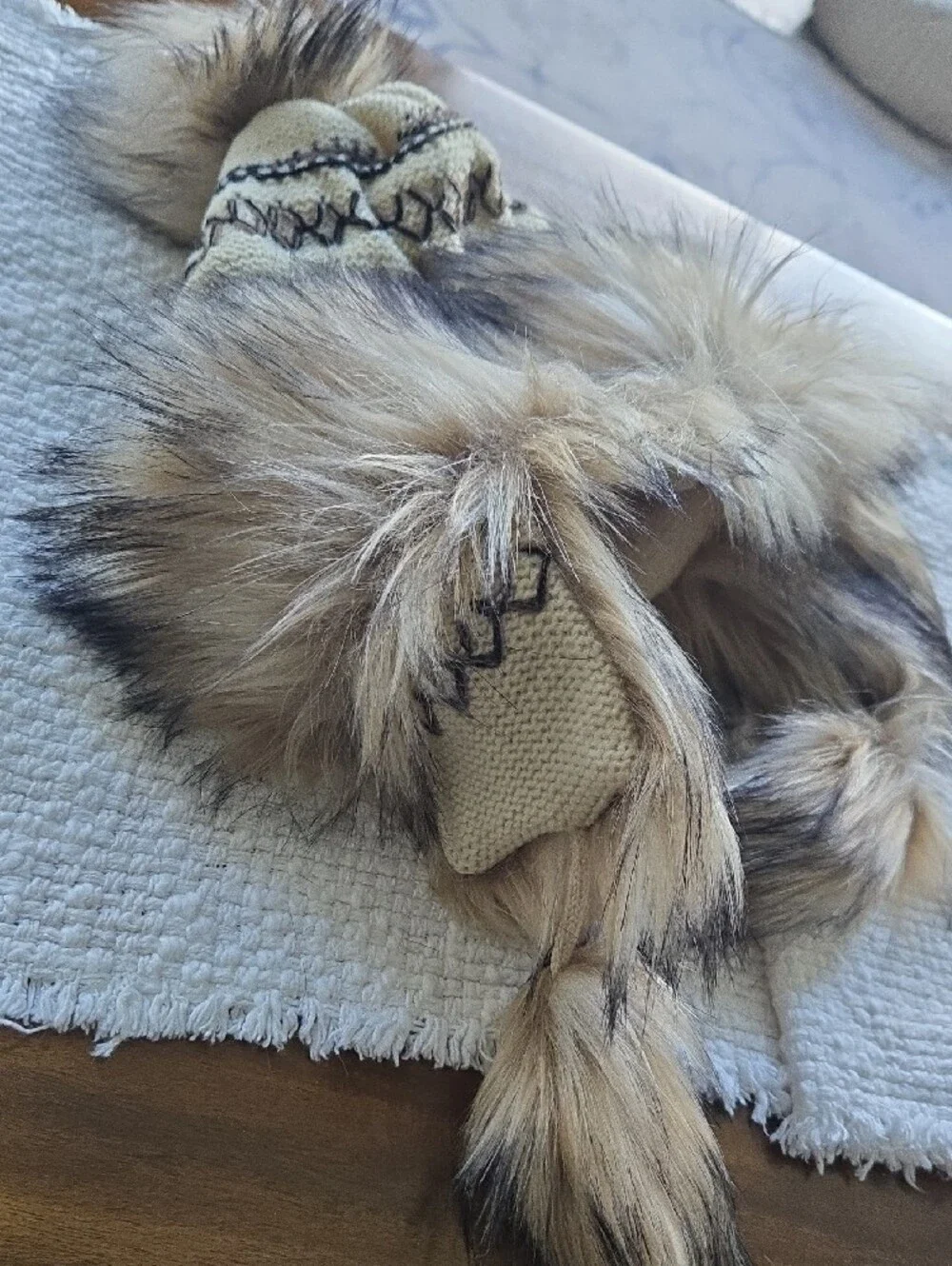 Cross stitch knit trapper beanie features a fleece lining, faux fur trim